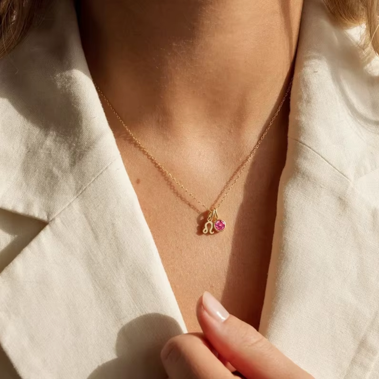 Astrological Birthstone Pendant on model. Crafted from stainless steel and available in luxurious 14K gold, sleek silver, or rose gold plating, this necklace features your zodiac sign alongside your birthstone.