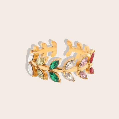 Bali Botanical Eternity Band. This eye-catching, adjustable ring features a captivating leaf-shaped design adorned with multi-colored AAA zirconia stones, all set on stainless steel with IP gold plating.