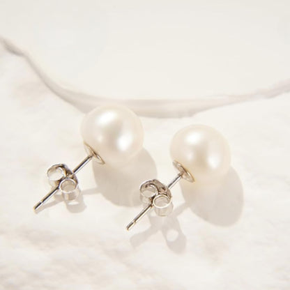 Bianca Baroque Pearl Studs in white. These stunning earrings feature unique freshwater pearls nestled in 925 sterling silver settings and plated with 18K gold.