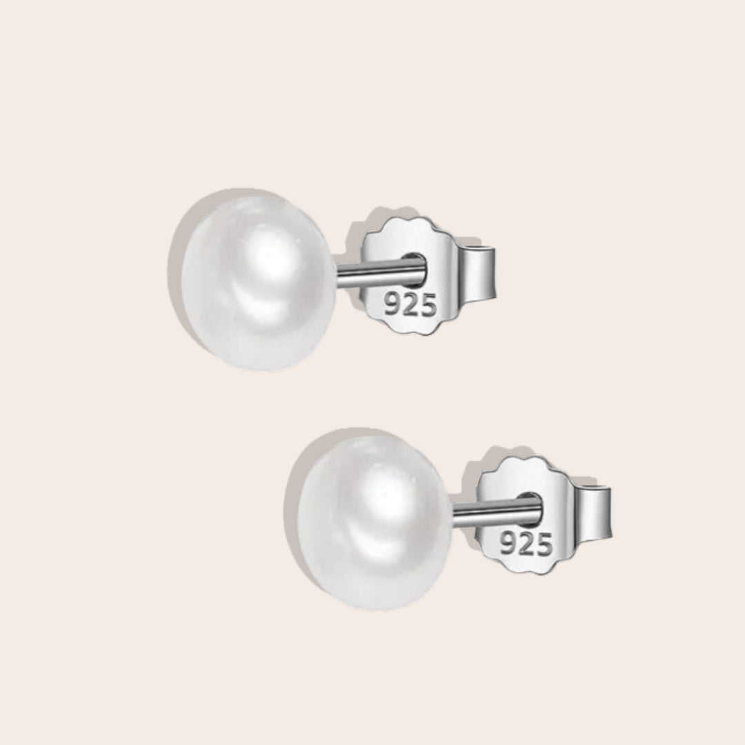 Bianca Baroque Pearl Studs in white. These stunning earrings feature unique freshwater pearls nestled in 925 sterling silver settings and plated with 18K gold.