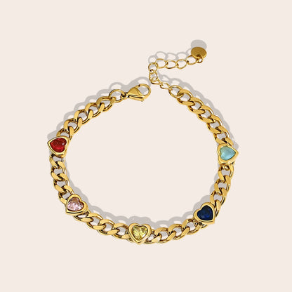 Caeli Charmed Hearts Bracelet. This stainless steel piece features five vibrant zircon stones nestled within heart charms in a bold, flat cuban chain link.