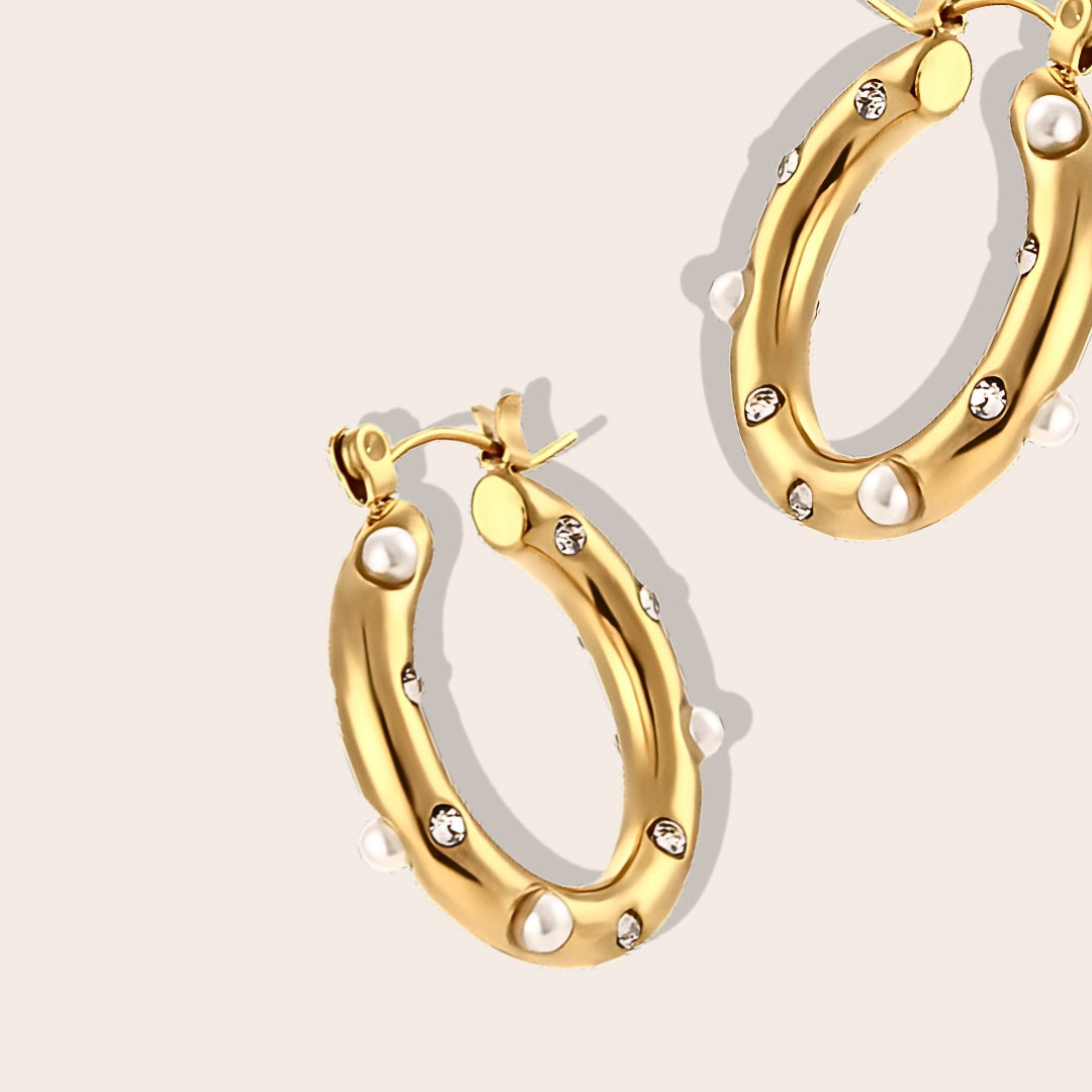 Close up of Caia Classic Studded Huggies. These exquisite earrings, crafted from 18K gold plated stainless steel, feature a dazzling array of zircon stones or pearls.