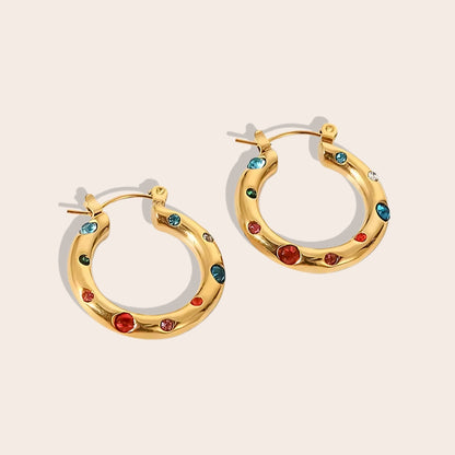 Caia Classic Studded Huggies. These exquisite earrings, crafted from 18K gold plated stainless steel, feature a dazzling array of zircon stones or pearls.