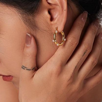 Caia Classic Studded Huggies. These exquisite earrings, crafted from 18K gold plated stainless steel, feature a dazzling array of zircon stones or pearls.