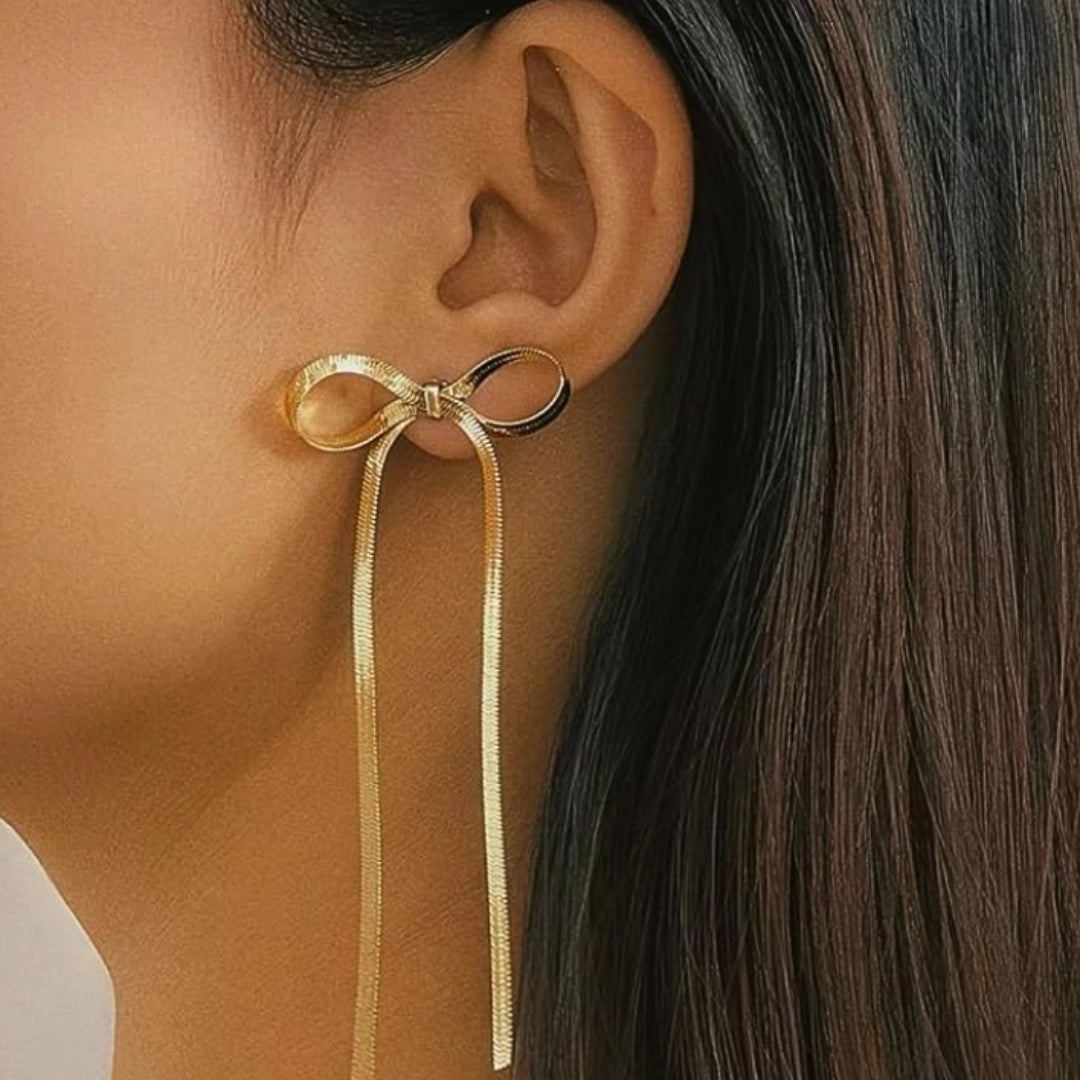 Coquette Bow Drop Earrings in gold on model. Constructed from lasting stainless steel.