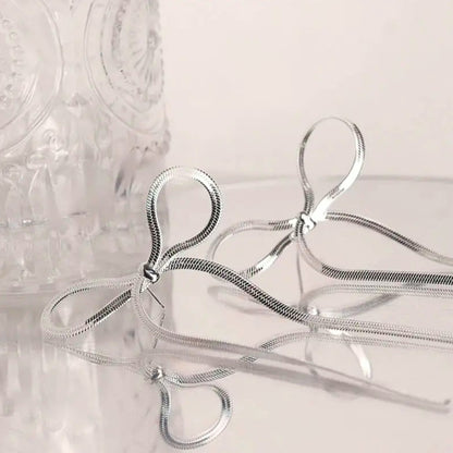 Coquette Bow Drop Earrings in silver. Constructed from lasting stainless steel.