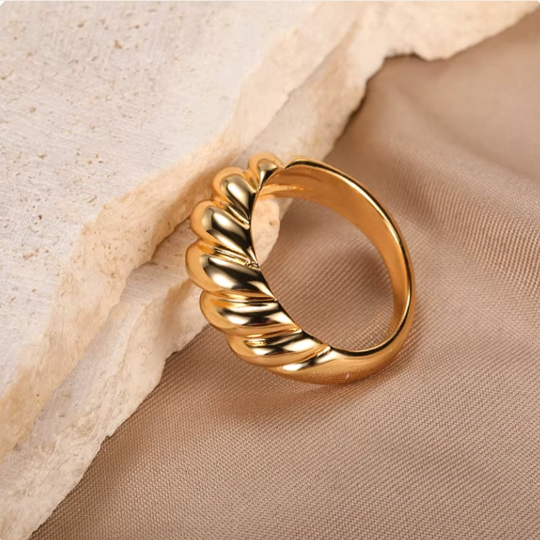 Crafted from durable stainless steel and luxuriously plated with 18K gold, this chunky ring features a unique twist design. Lifestyle shot 2.