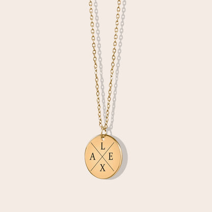 Personalized initials necklace studio shot. Gold coin shape with gold chain.