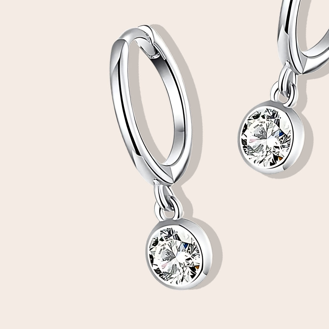 Close up of Dara Drop Huggies, featuring premium 925 sterling silver and pavé set cubic zirconia stones.