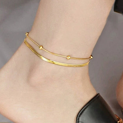 Dion Dual Chain Anklet on model. Constructed from stainless steel, this anklet features a delightful duo of chains.