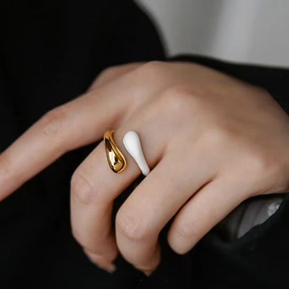 Enid Enamel Wrap Ring in white, on model. This eye-catching piece features an open, spiral design that gracefully wraps around your finger, combining the durability of stainless steel with the vibrant allure of enamel.