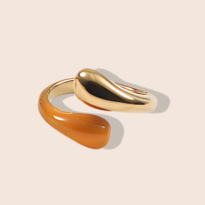 Enid Enamel Wrap Ring in orange. This eye-catching piece features an open, spiral design that gracefully wraps around your finger, combining the durability of stainless steel with the vibrant allure of enamel.