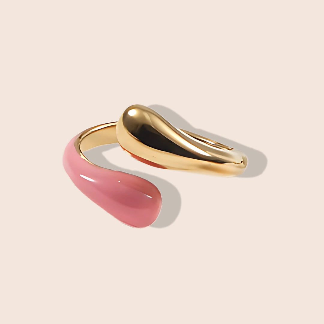 Enid Enamel Wrap Ring in pink. This eye-catching piece features an open, spiral design that gracefully wraps around your finger, combining the durability of stainless steel with the vibrant allure of enamel.