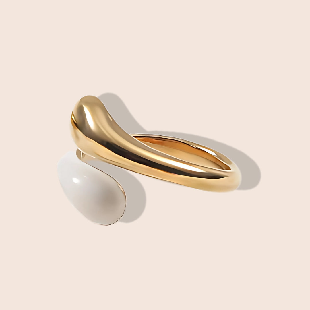 Enid Enamel Wrap Ring in white. This eye-catching piece features an open, spiral design that gracefully wraps around your finger, combining the durability of stainless steel with the vibrant allure of enamel.