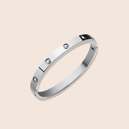 Harlow Hinged Bangle in silver, a dazzling fusion of sleek stainless steel and twinkling zircon stones.