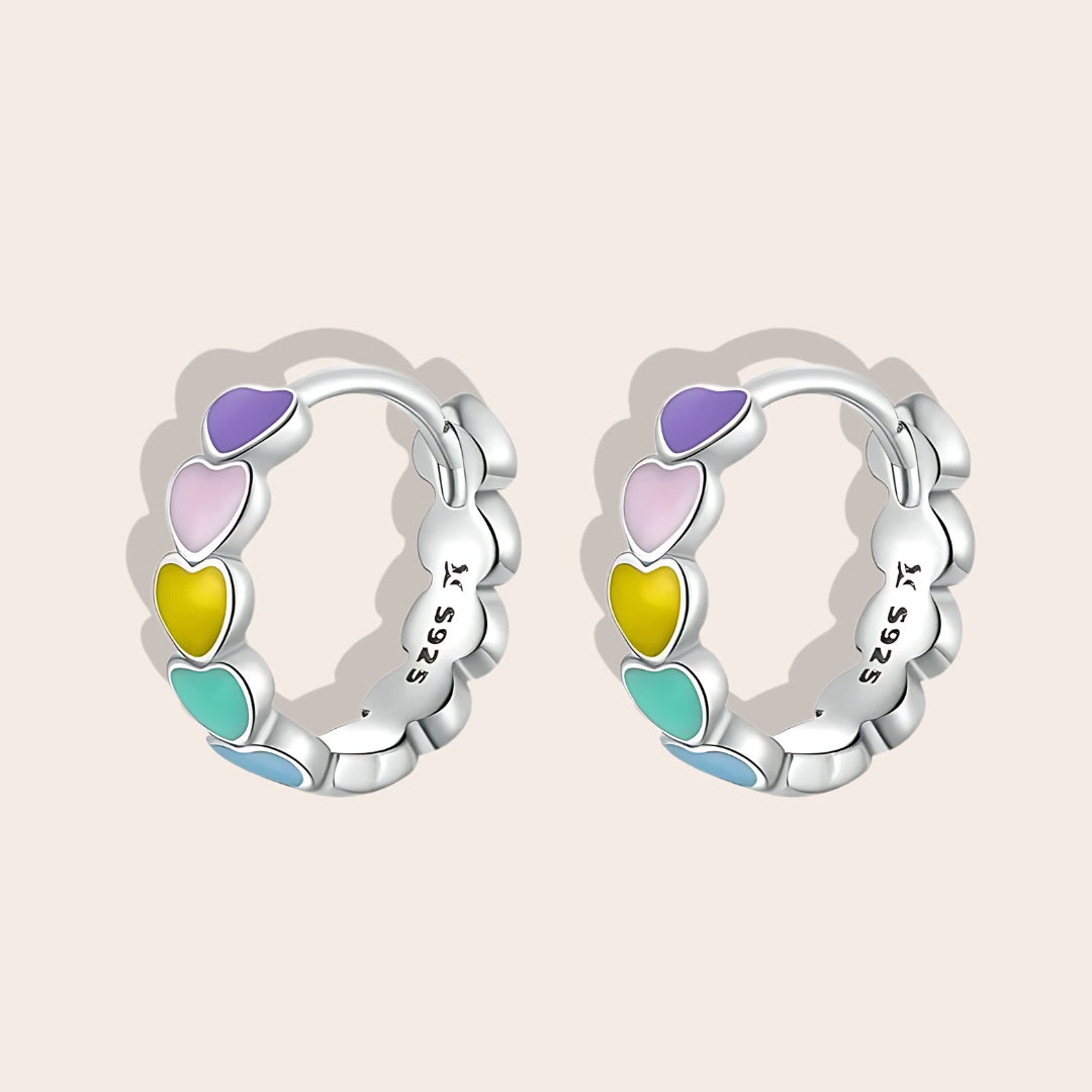 Heart-to-Heart Huggies. Crafted from premium 925 sterling silver, these earrings feature a heart-to-heart design, beautifully accented with splashes of color.