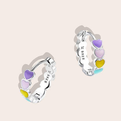 Heart-to-Heart Huggies. Crafted from premium 925 sterling silver, these earrings feature a heart-to-heart design, beautifully accented with splashes of color.