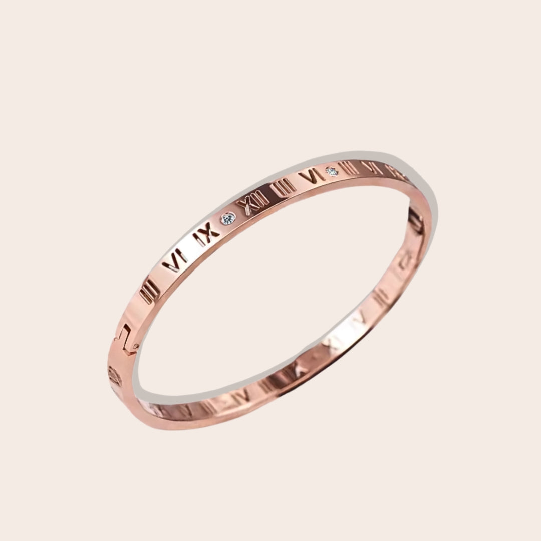 Crafted from stainless steel, this hinged bangle features eye-catching Roman numerals and sparkling zircon stones. In rose gold.