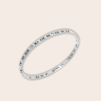 Crafted from stainless steel, this hinged bangle features eye-catching Roman numerals and sparkling zircon stones. In silver.