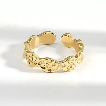 Hutton Hammered Ring in gold, made of stainless steel, features a unique scalloped design with a hammered texture. Lifestyle shot.