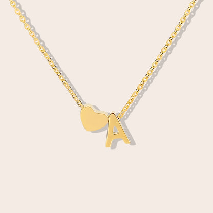 Inez Initial Heart Pendant. Crafted from stainless steel and finished in a luxurious gold hue.