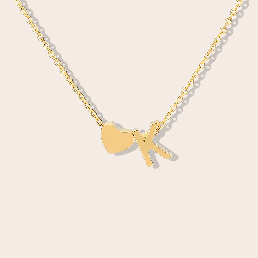 Inez Initial Heart Pendant. Crafted from stainless steel and finished in a luxurious gold hue.