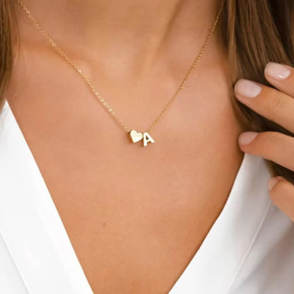 Inez Initial Heart Pendant. Crafted from stainless steel and finished in a luxurious gold hue on model.