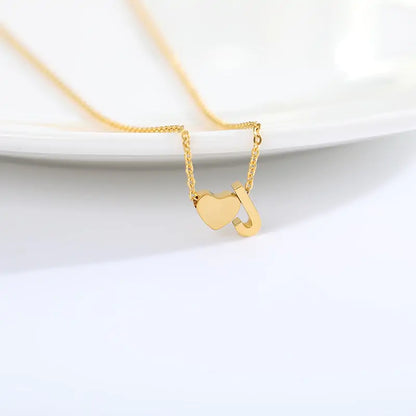 Inez Initial Heart Pendant. Crafted from stainless steel and finished in a luxurious gold hue.