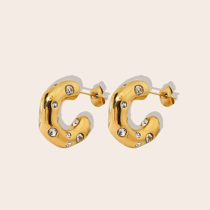 Iris Irregular Studded Huggies. Crafted from 18K gold plated stainless steel, feature an irregular, chunky shape with an enchanting array of zircon stones.