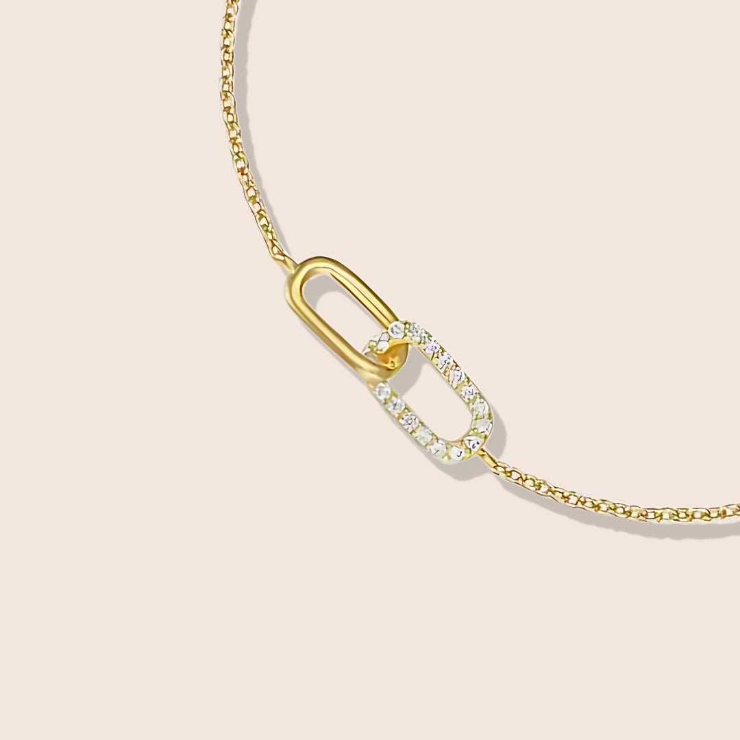 Close up of Isla Interlocking Pave Bracelet, a stunning fusion of 925 sterling silver and luxurious 18K gold plating, set with zircon stones. In gold, on model.