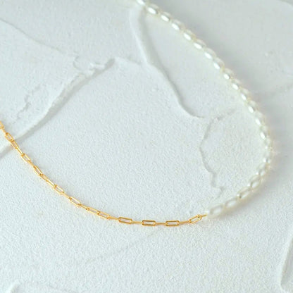 Mona Millet Pearl Choker in gold. This eye-catching piece features lustrous pearls paired with a delicate paperclip chain, all crafted from premium 925 sterling silver for lasting beauty and comfort.