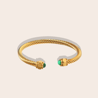 Naima Natural Stone Bangle. Crafted from 18K gold plated stainless steel, this exquisite piece features a playful twist pave opening with natural stones on both ends.