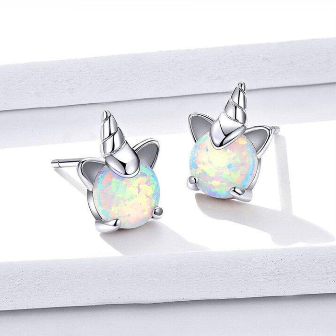 Opal Unicorn Stud Earrings, lifestyle shot. Crafted from 925 sterling silver, plated with platinum, and adorned with shimmering white opals.