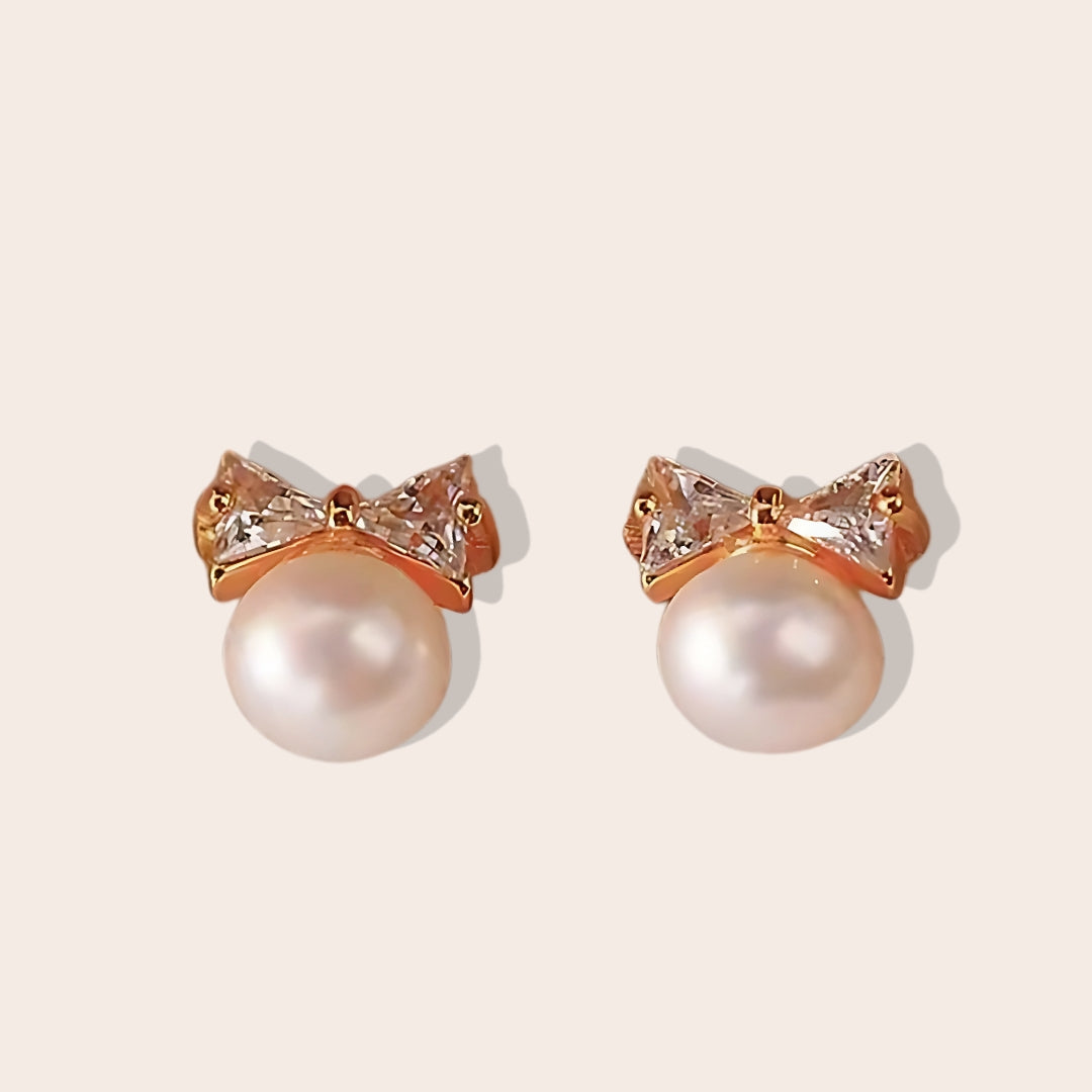 Paloma Pearl Bow Studs, crafted from 925 sterling silver and adorned with shimmering zircon stones in gold.