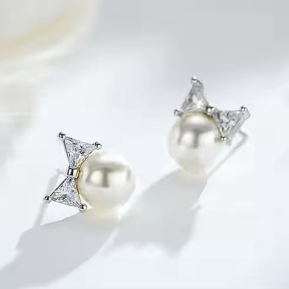 Paloma Pearl Bow Studs, crafted from 925 sterling silver and adorned with shimmering zircon stones in silver. Lifestyle shot.