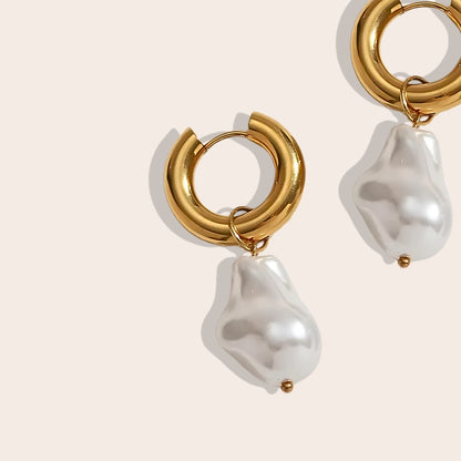 Close up of stainless steel PVD plated pearl drop earrings.