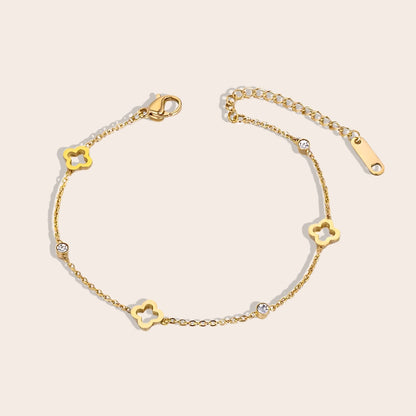 Quinn Quatrefoil Cutout Bracelet. This charming piece in gold features an intricate quatrefoil cutout design in lustrous gold plated stainless steel, accented by AAA zircon stones.