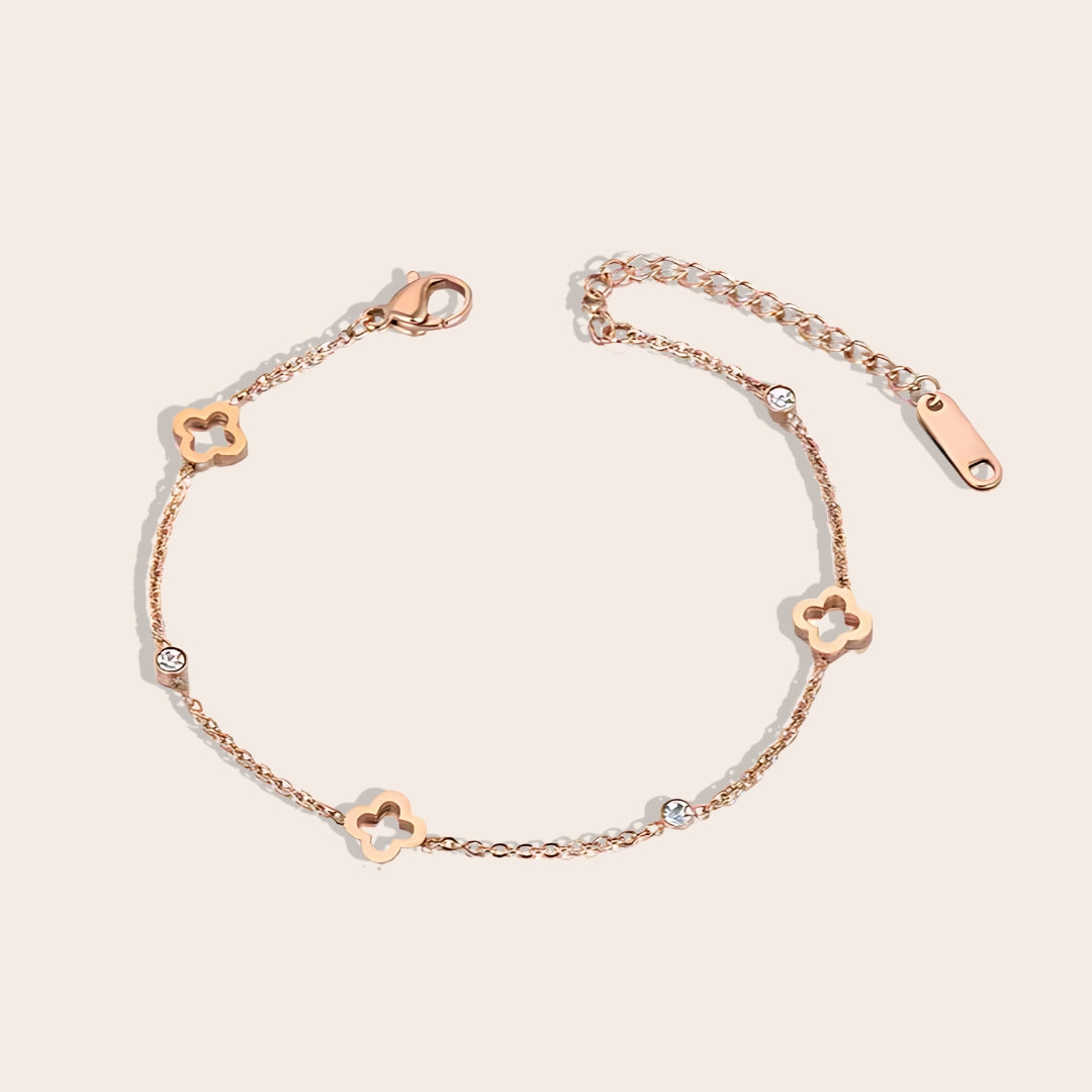 Quinn Quatrefoil Cutout Bracelet. This charming piece in rose gold features an intricate quatrefoil cutout design in lustrous gold plated stainless steel, accented by AAA zircon stones.