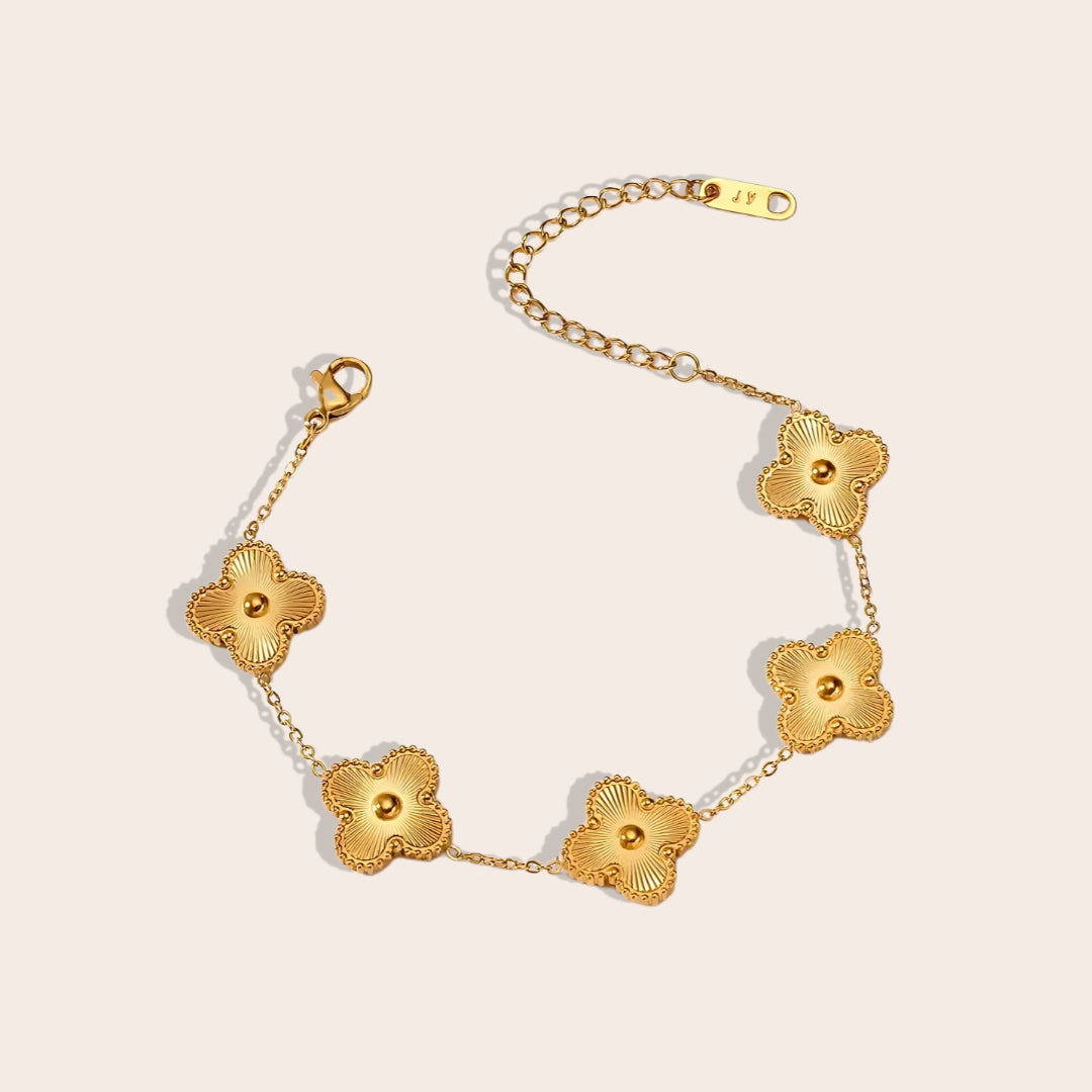 This charming piece in gold features five delicate quatrefoil charms, crafted in stainless steel and lavishly plated in 18K gold.