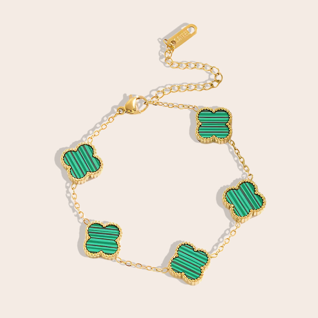 This charming piece in green features five delicate quatrefoil charms, crafted in stainless steel and lavishly plated in 18K gold.