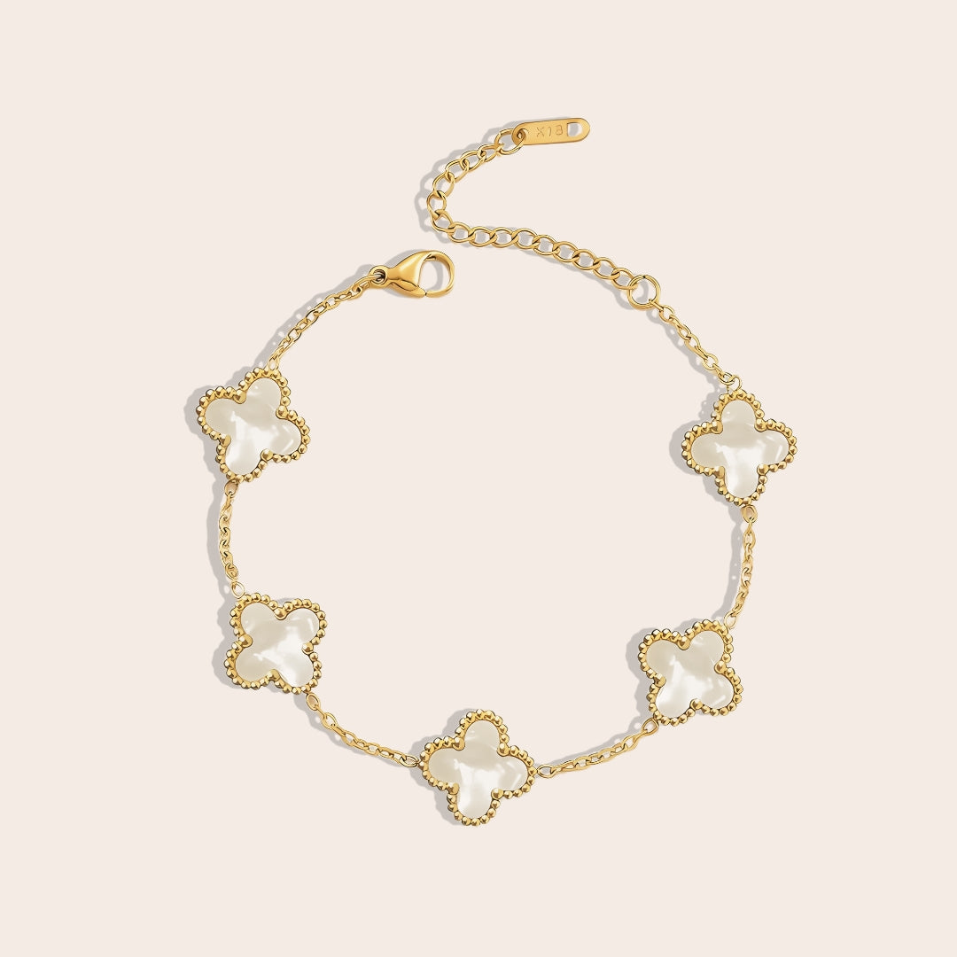 This charming piece in white features five delicate quatrefoil charms, crafted in stainless steel and lavishly plated in 18K gold.