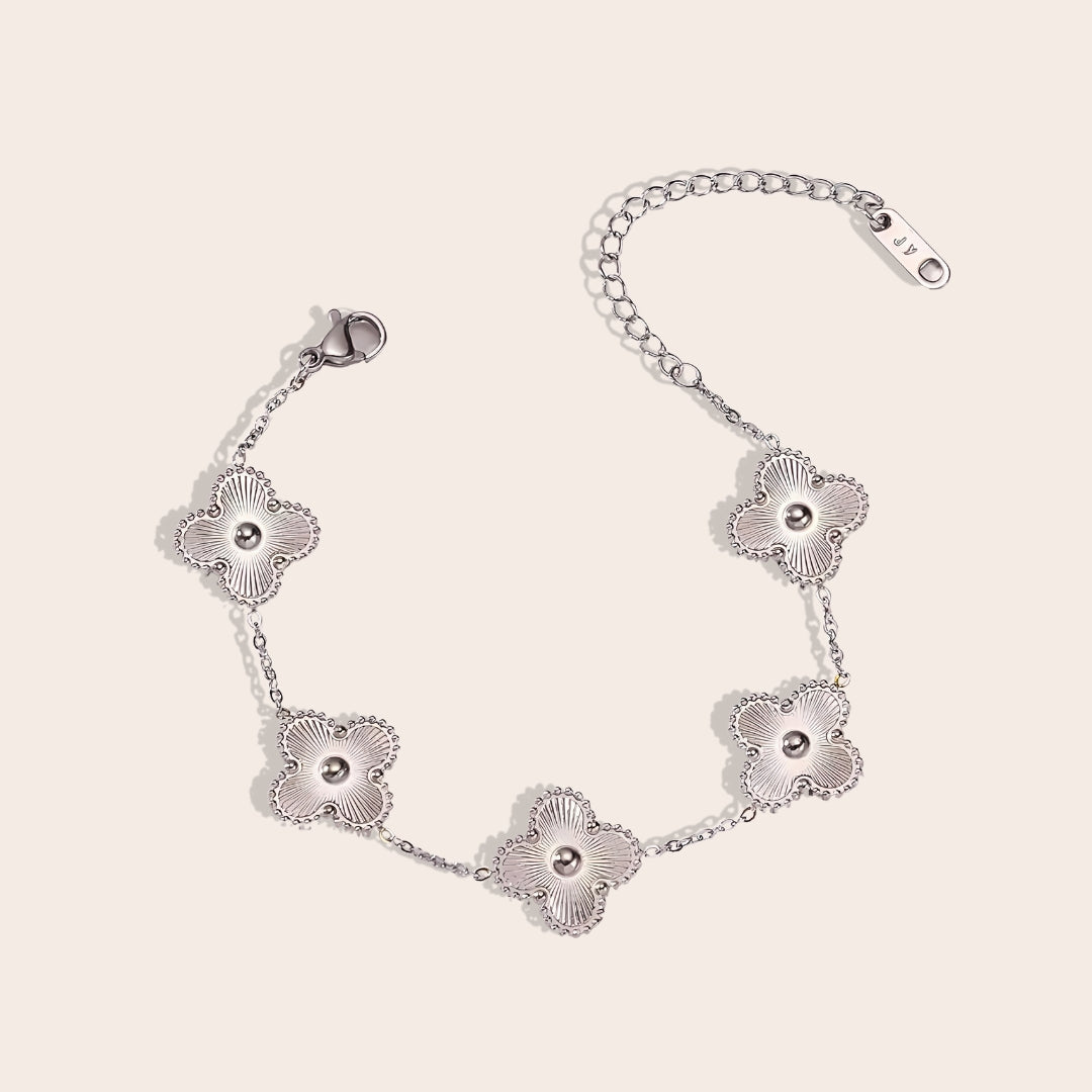 This charming piece in silver features five delicate quatrefoil charms, crafted in stainless steel and lavishly plated in 18K gold.