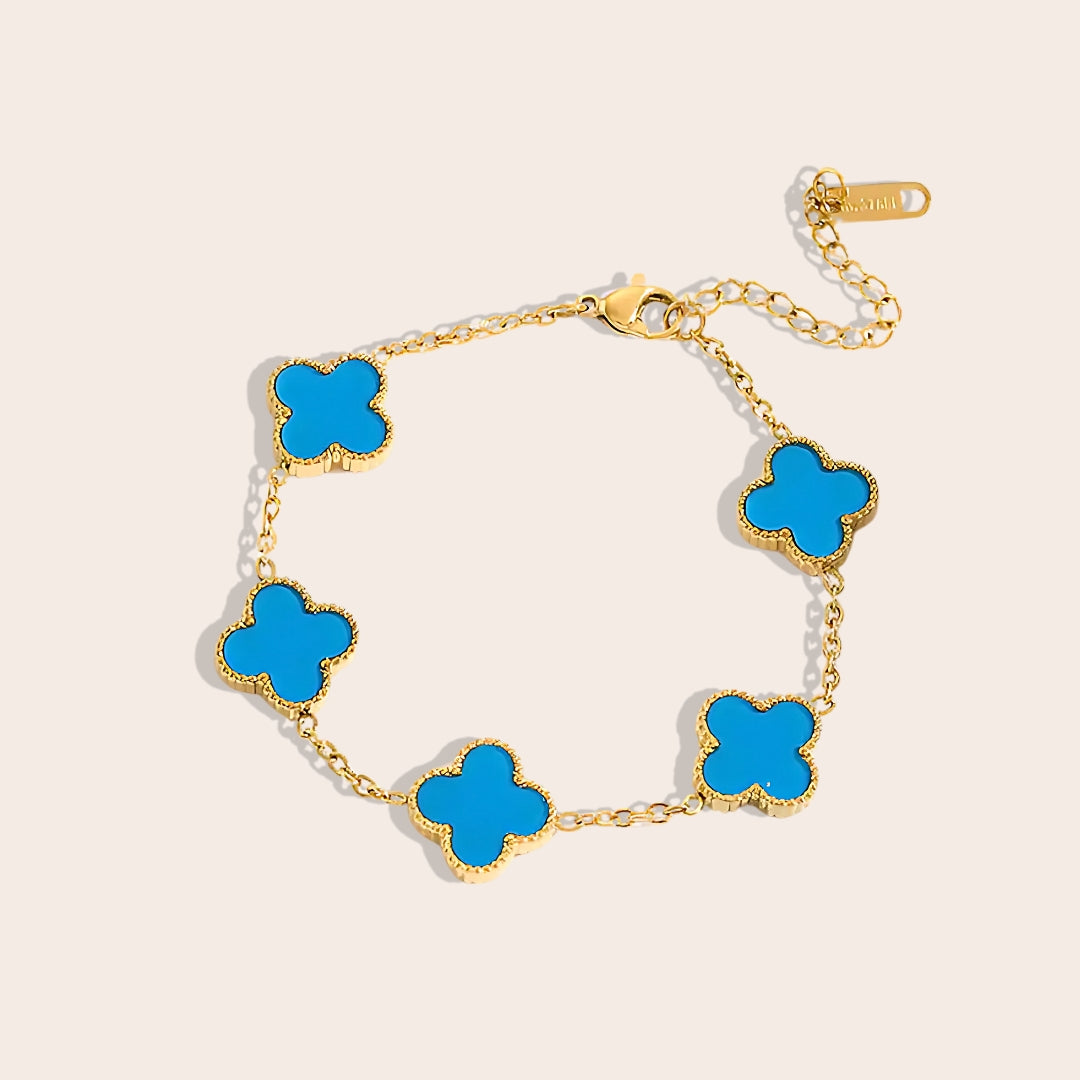 This charming piece in blue features five delicate quatrefoil charms, crafted in stainless steel and lavishly plated in 18K gold.