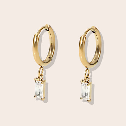 Rhea Rectangular Huggies in diamond. Made from stainless steel and plated with 18k gold, these earrings are inlaid with sparkling cubic zirconia.