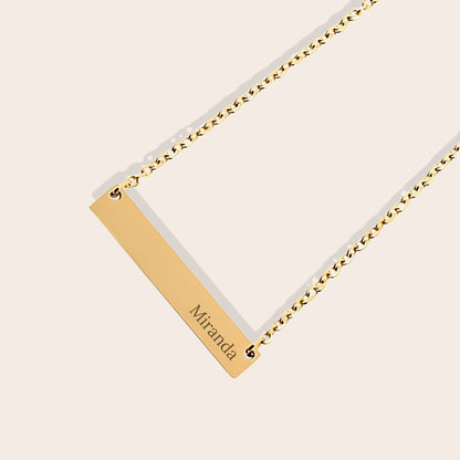 Customizable name necklace with front engraving and special message for back engraving. Gold, horizontal bar orientation. Close up