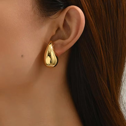 Medium Tais Teardrop Earrings on model. These eye-catching beauties, crafted from lightweight stainless steel and adorned with lustrous 18K gold plating.