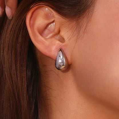 Medium Tais Teardrop Earrings on model. These eye-catching beauties, crafted from lightweight stainless steel and adorned with lustrous 18K gold plating.