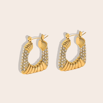 Tessa Trapeze Earrings. Constructed from highly durable titanium steel, plated with 18K gold and inlaid with radiant cubic zirconia.