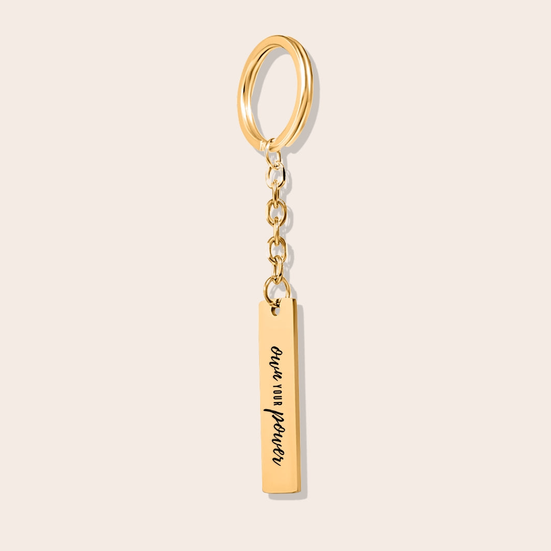 Vertical Bar Keychain - Own Your Power in gold. Crafted from stainless steel and adorned with lustrous 18K gold plating, this chic piece features a laser-engraved affirmation.