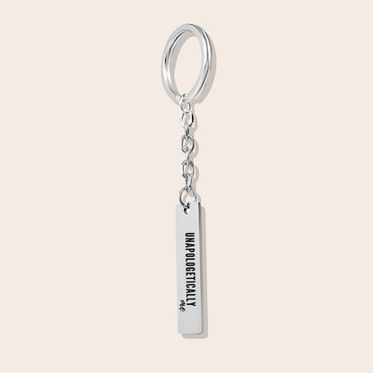 Vertical Bar Keychain - Unapologetically Me, in silver. Created from stainless steel and plated with 18K gold, this sleek piece features a laser-engraved affirmation.